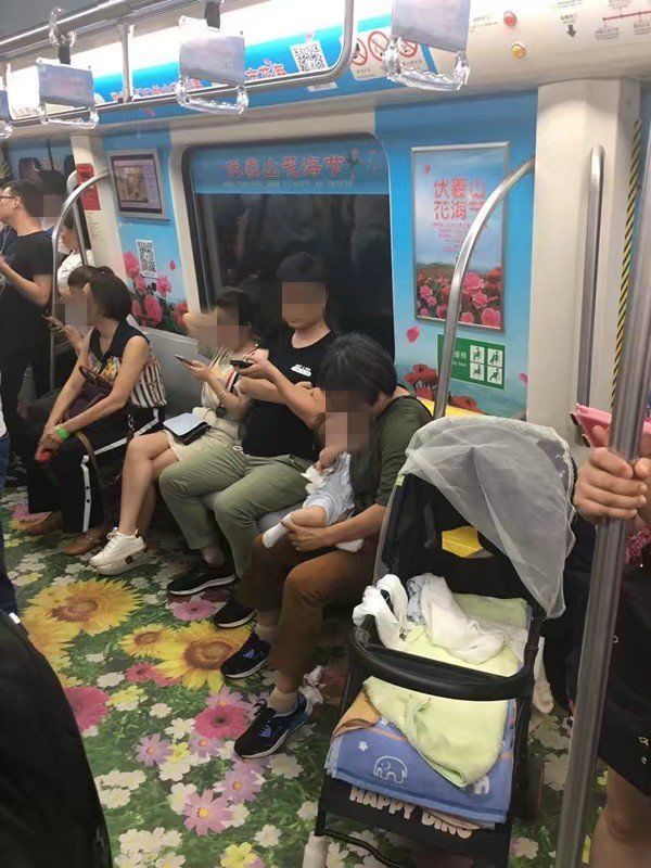 地铁上年轻女子给孩子喂奶,做出一动作,旁人看