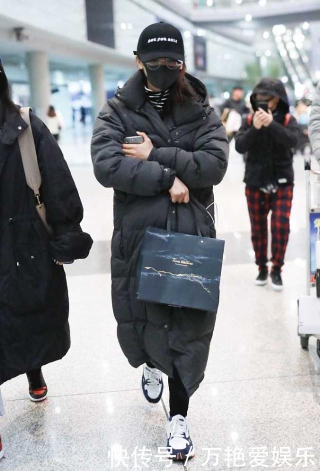 杨超越凌晨现身机场呆萌抱胸 超长羽绒服从头