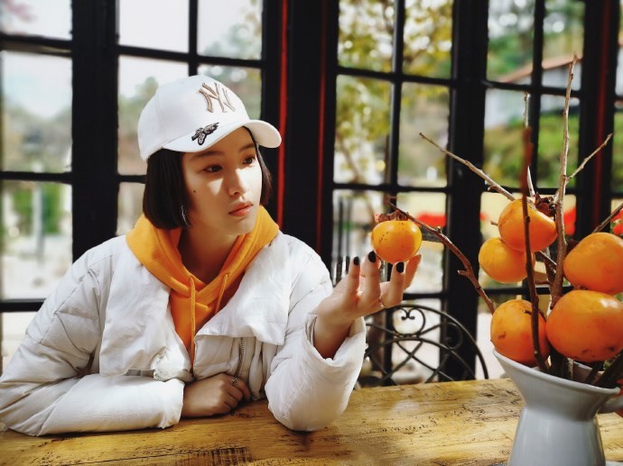 杜雨宸橙色连帽卫衣搭配白色羽绒服,轻松休闲