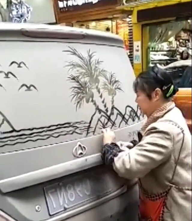 小伙看到大妈在自己车上乱画,准备上前理论,结果却是佩服不已
